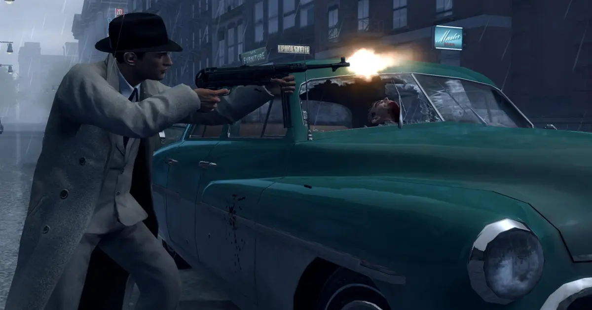 Vito Scaletta zoekt dekking achter een klassieke auto tijdens een vuurgevecht in Mafia II: Definitive Edition
